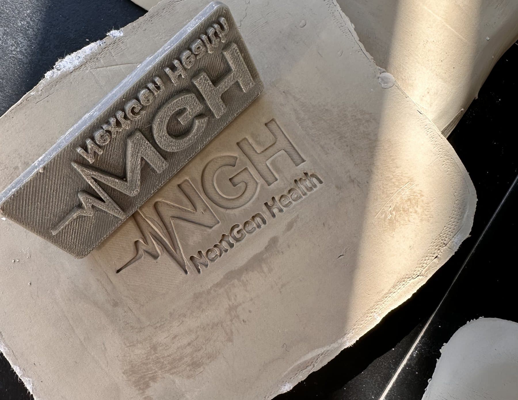 The first batch of cards: the stamp on the next clay slab, impressions drying alongside.