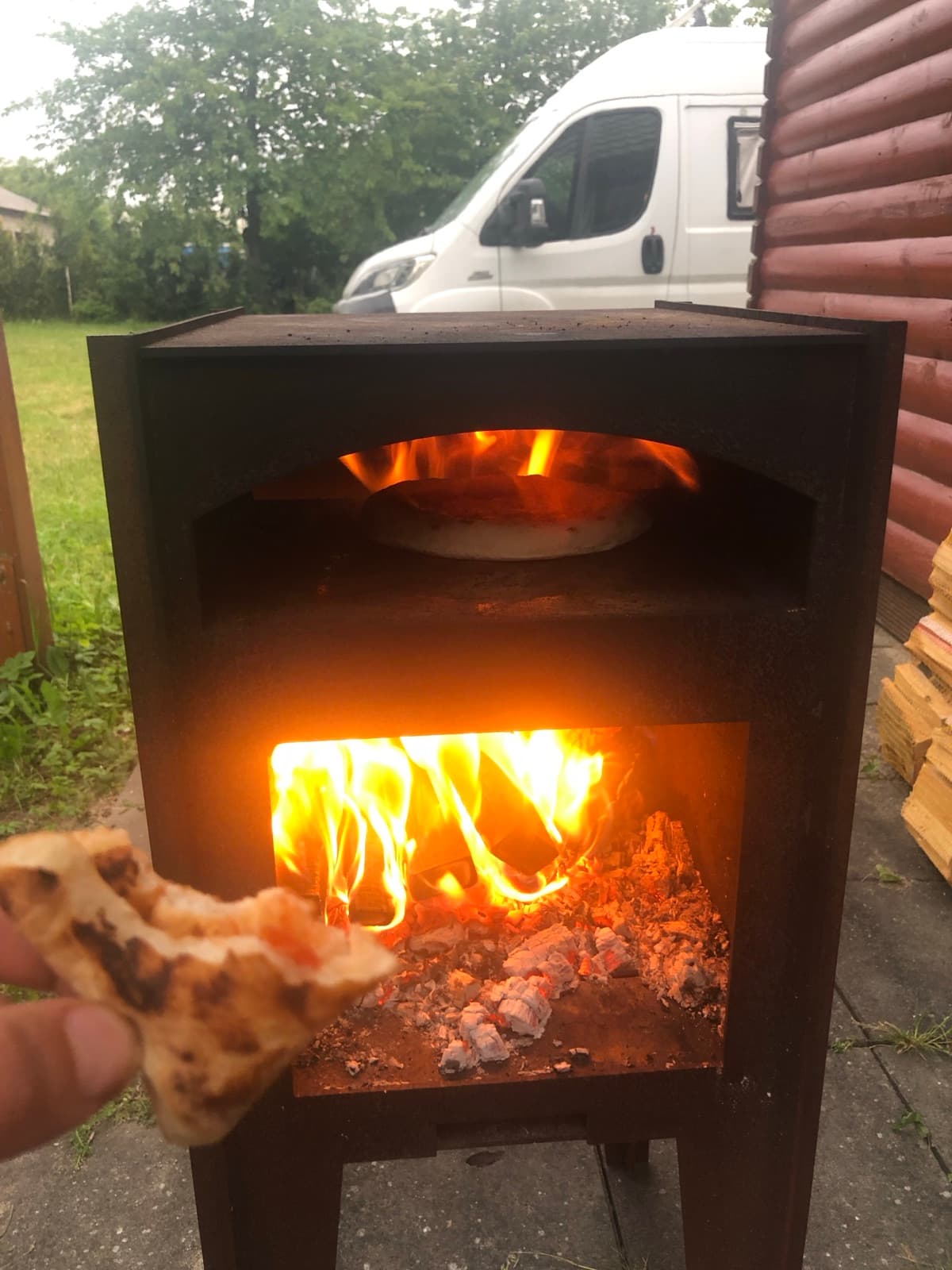 Kawałek pizzy podany przy rozpalonym piecu.
