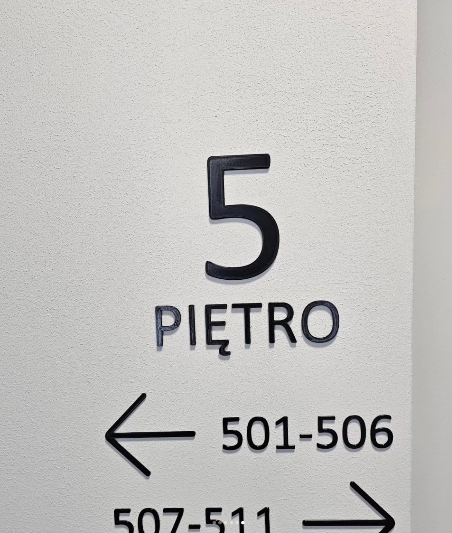 Floor 5 wayfinding sign with directional apartment ranges on the wall