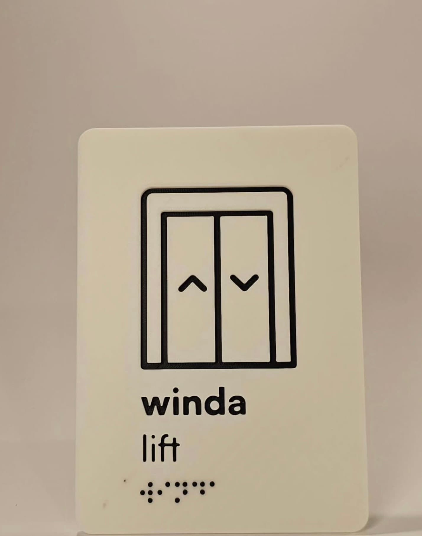 Elevator sign with pictogram and braille from the same signage set