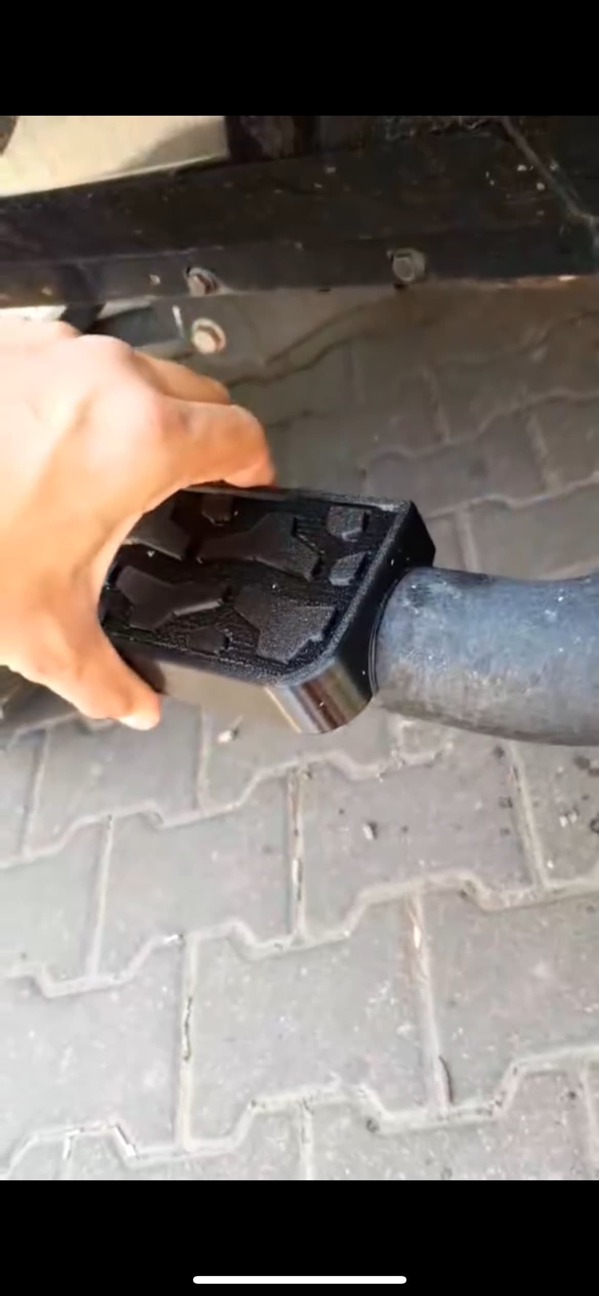 Close-up of the step clamped onto the end of the tubular bar, hand for scale.