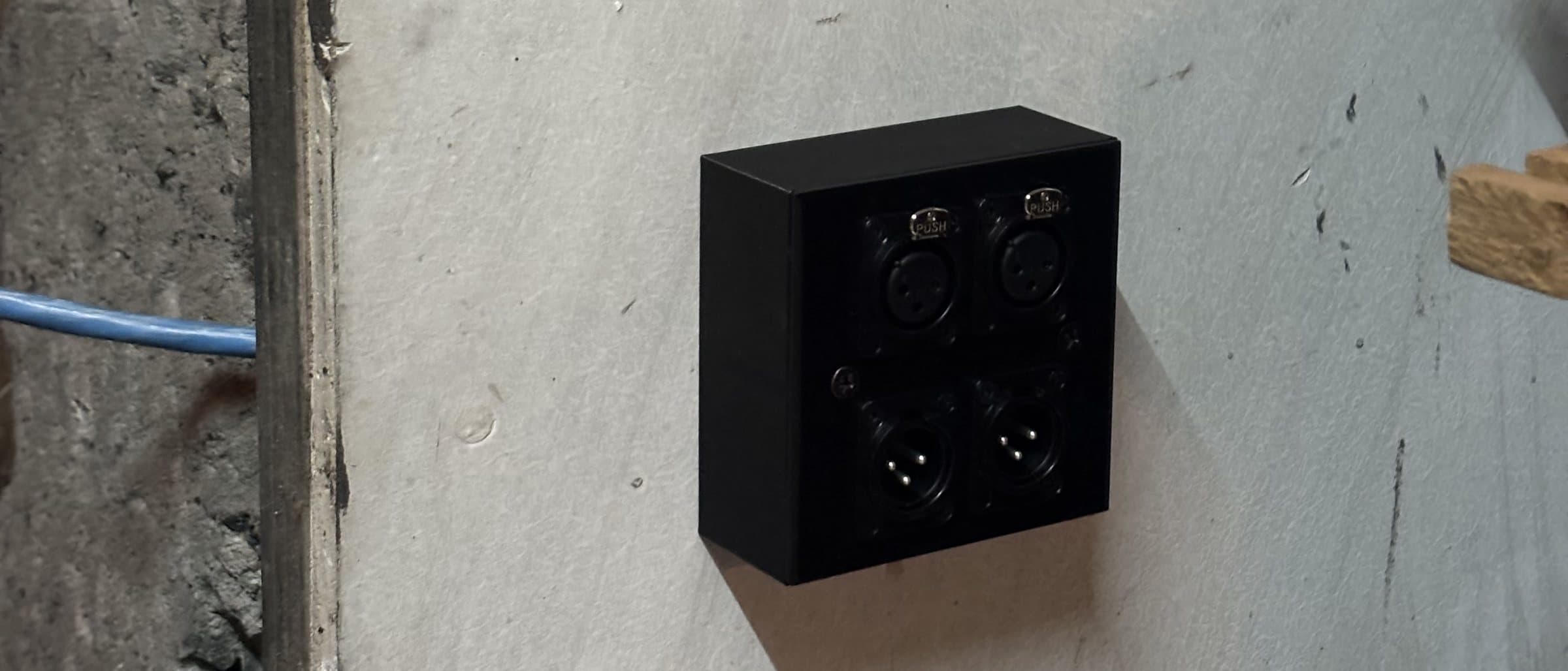 The finished box with the 4x XLR plate on the studio wall, cable run along the wall.